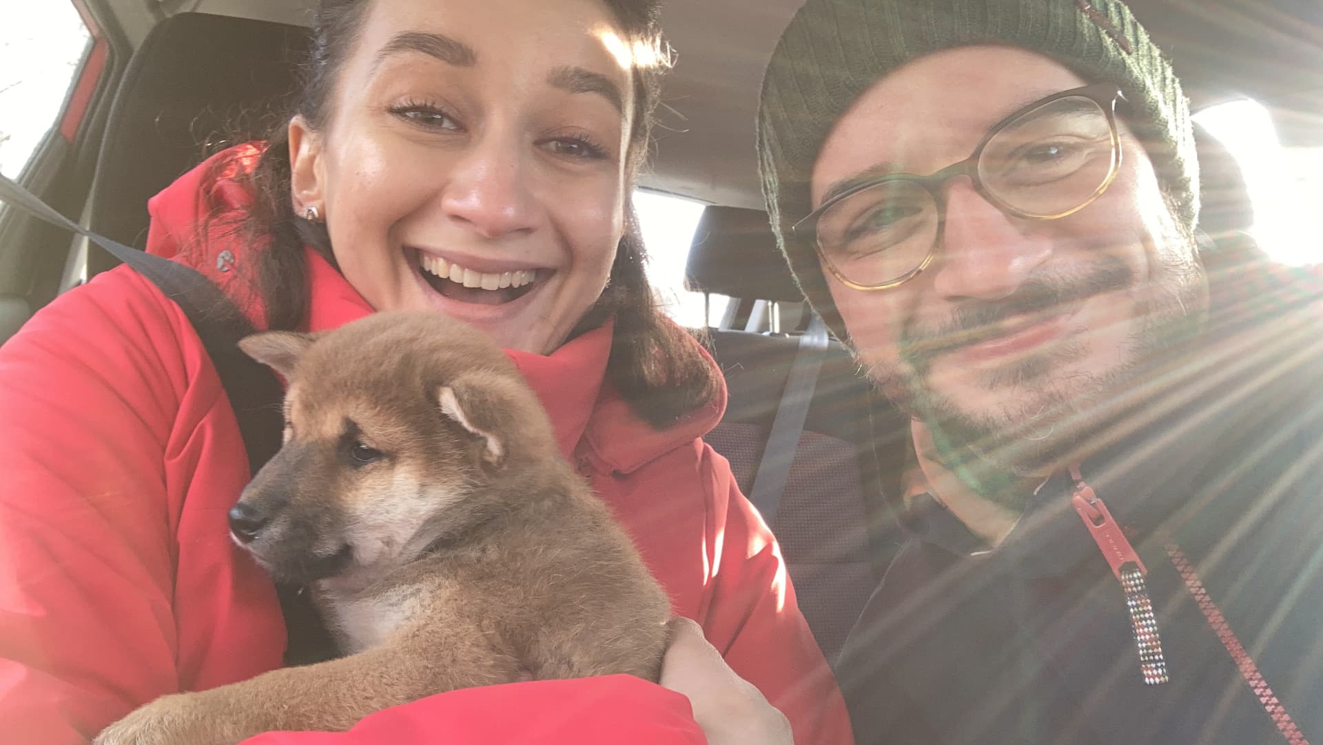 Olya and Andrei in the car with Toshi as a puppy