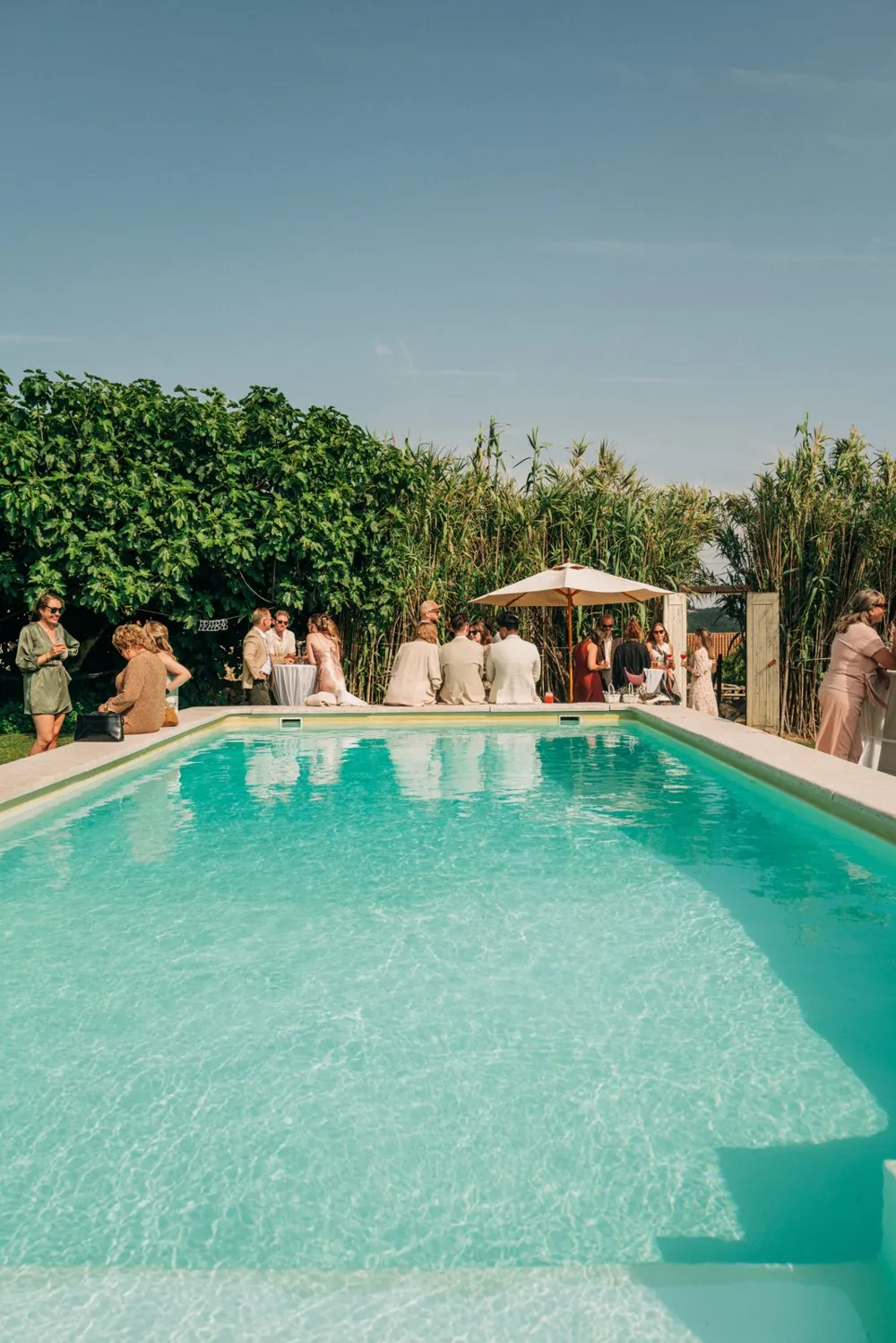 Guests gathering beside the turquoise pool at Casa Paço d'Ilhas